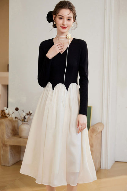Front view of black top and white skirt outfit with V-neckline detail