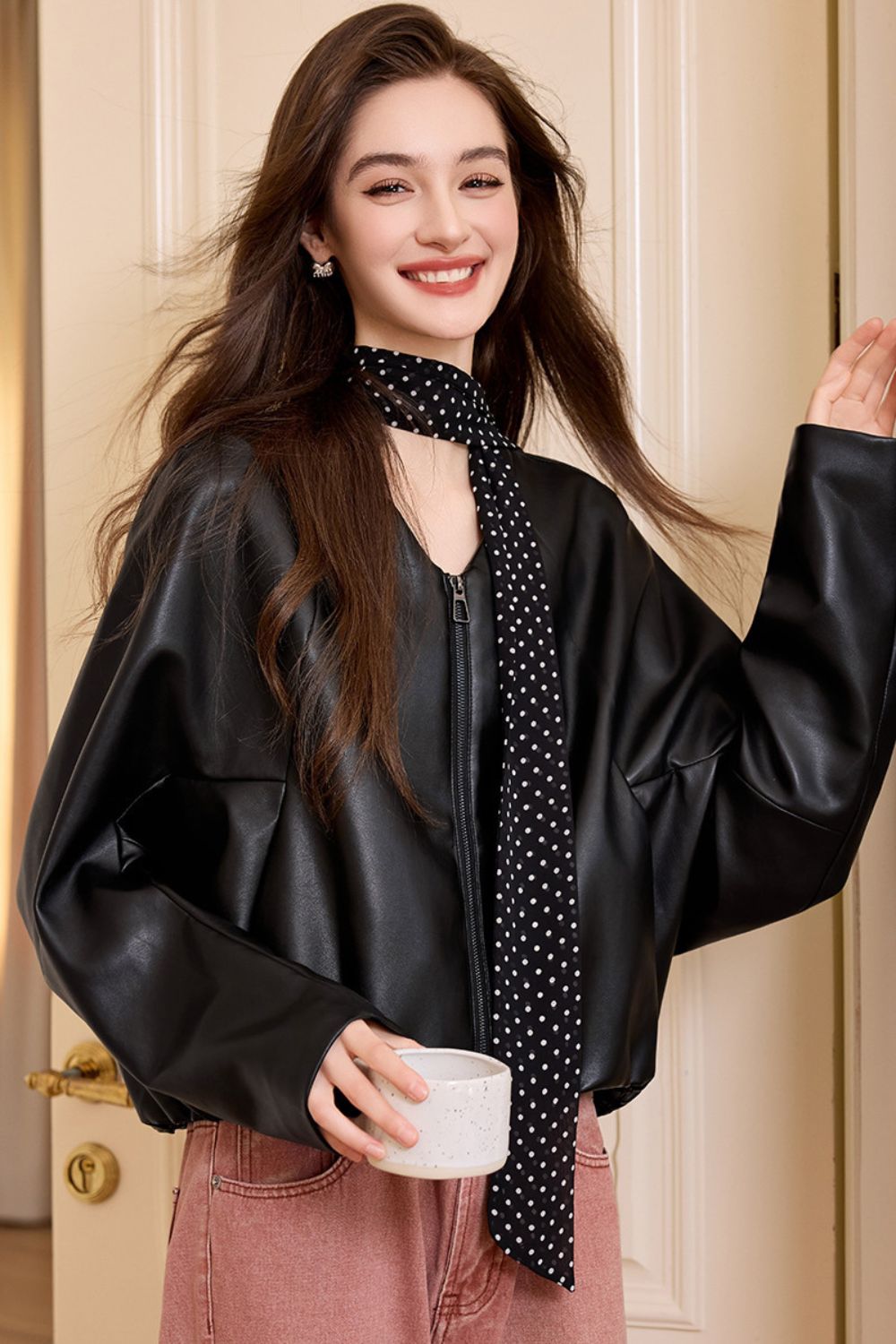 Side view of black faux leather jacket paired with casual outfit