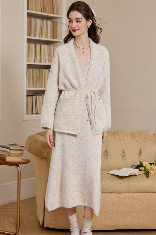 Front view of woman wearing a cream long knit cardigan dress with waist tie