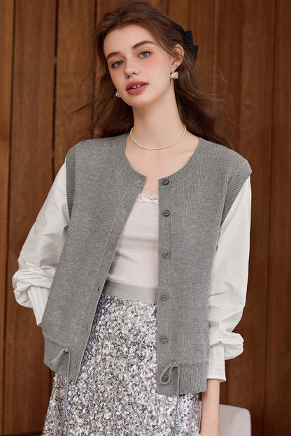 Side view of gray buttoned vest paired with a white blouse and floral skirt