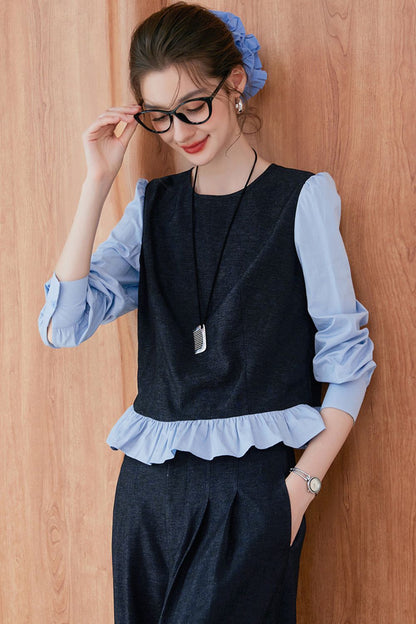 Model adjusting glasses while wearing navy blue vest and pants with light blue ruffle-trim blouse
