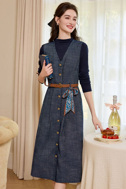 Angled view of denim midi dress with long sleeves and front pockets