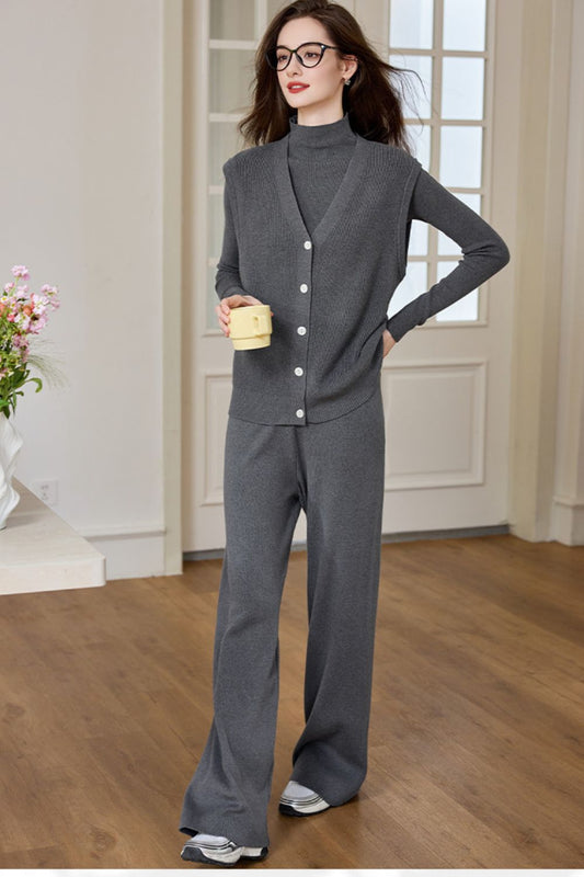 Model in a dark gray knit lounge set with long-sleeve top and wide-leg pants, posing indoors