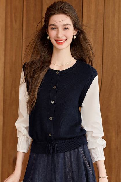 Smiling model in navy blue vest and white blouse paired with navy maxi skirt
