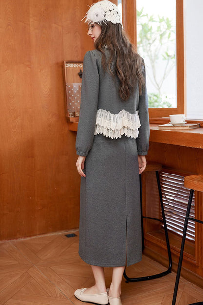 Back view of gray lace-trimmed blouse with long skirt and crochet hat